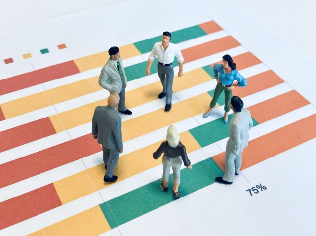 データを分析して話し合う6人のオフィスワーカー