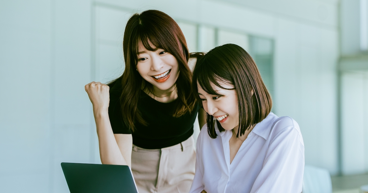 笑顔でパソコンを見る女性2人