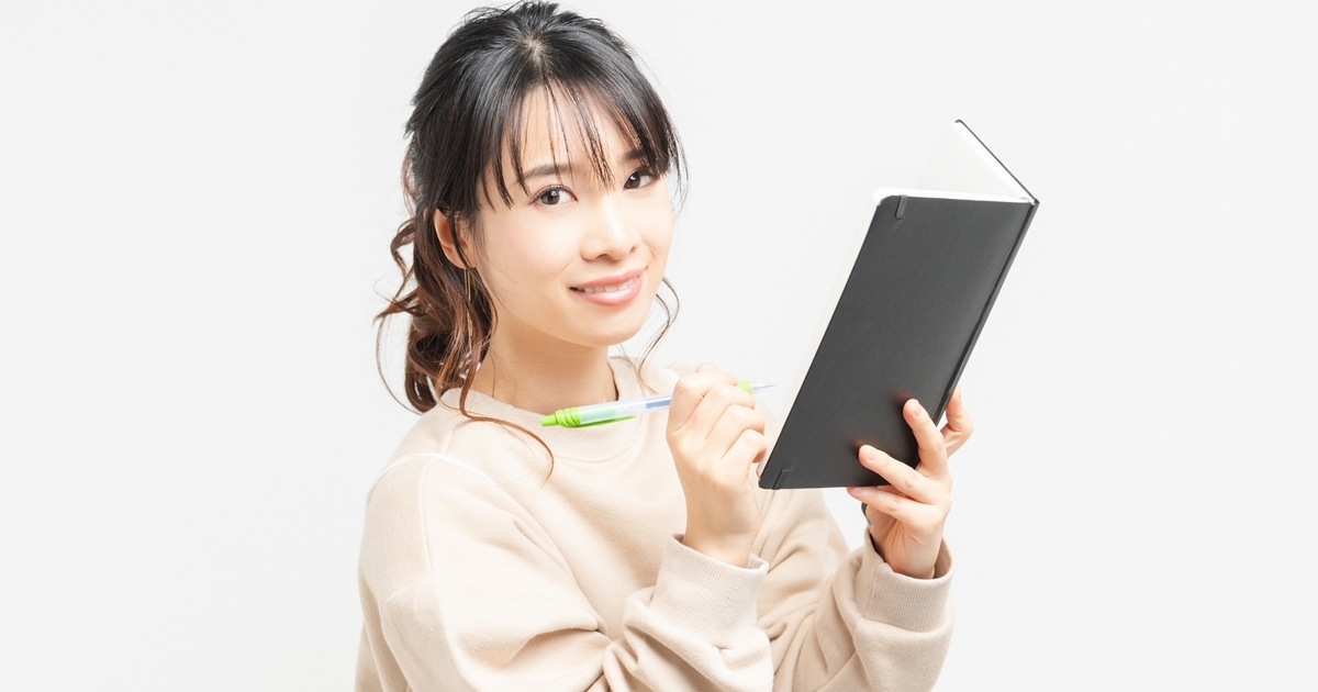 手帳に書き込むビジネスパーソン