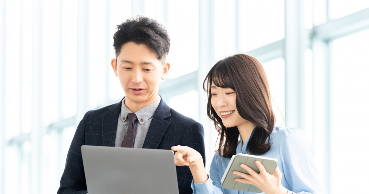話し合いながら仕事をするビジネスパーソン