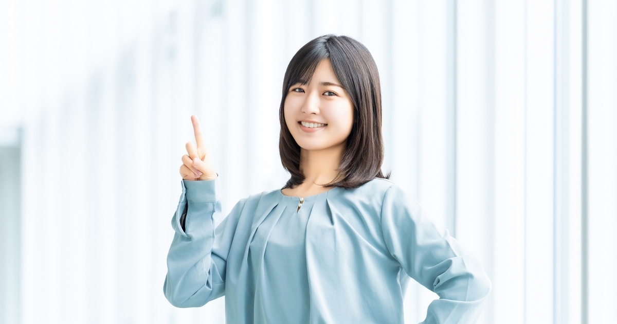 笑顔で人差し指を立てる女性