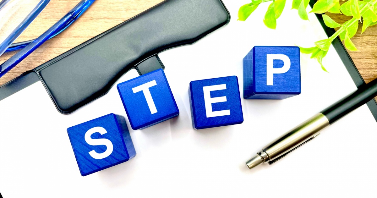 「STEP」と書かれた木製キューブとボールペン