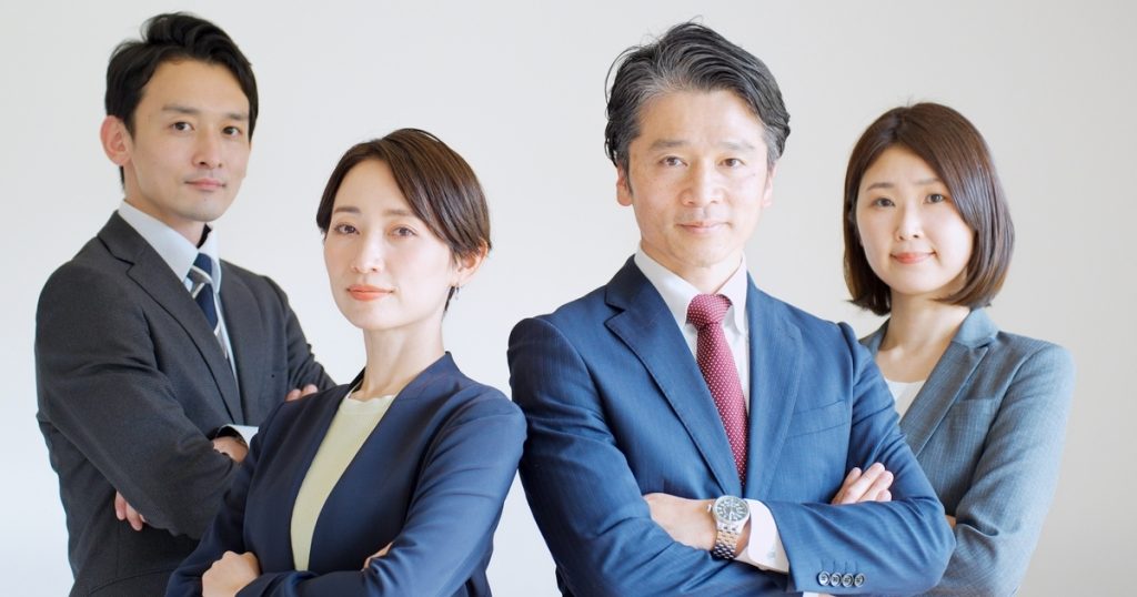 腕組みをする4人のビジネスパーソン