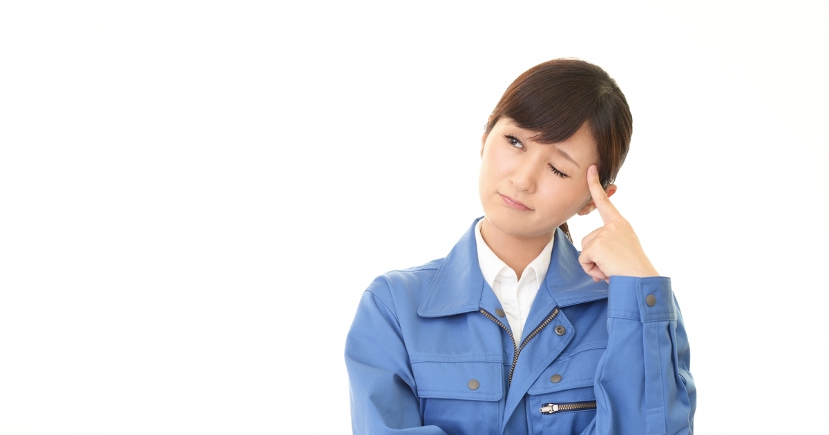 悩む作業着の女性