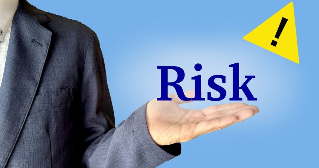 「RISK」とビジネスパーソンの手