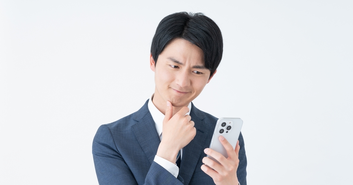 スマホを持って悩む男性