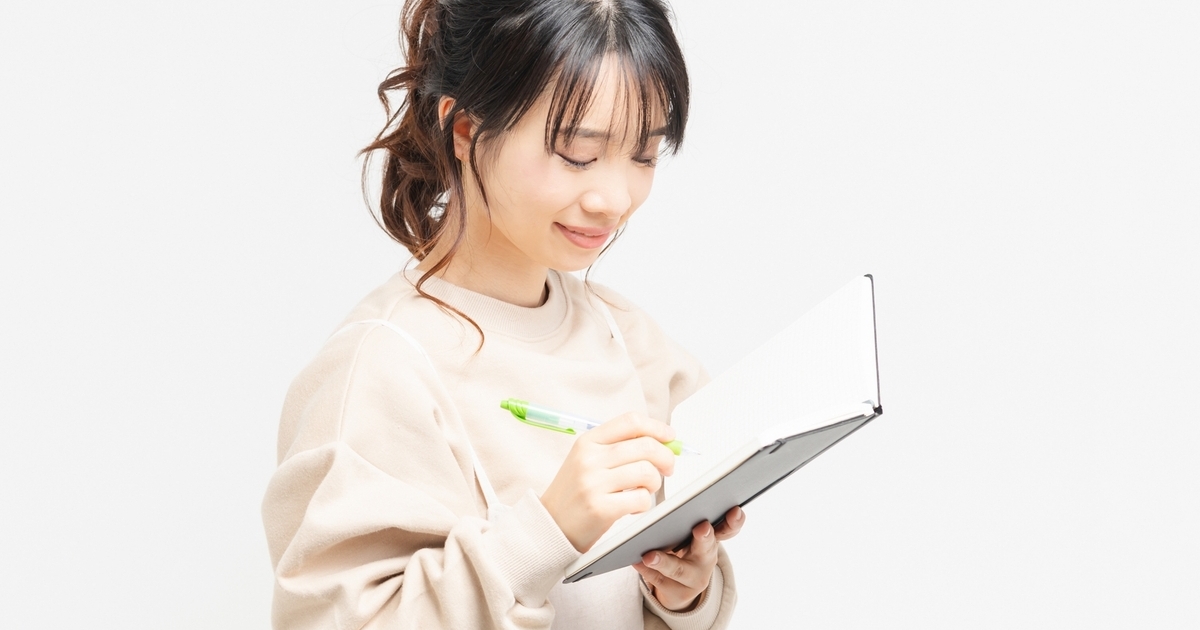 ノートにメモを書くビジネスパーソン