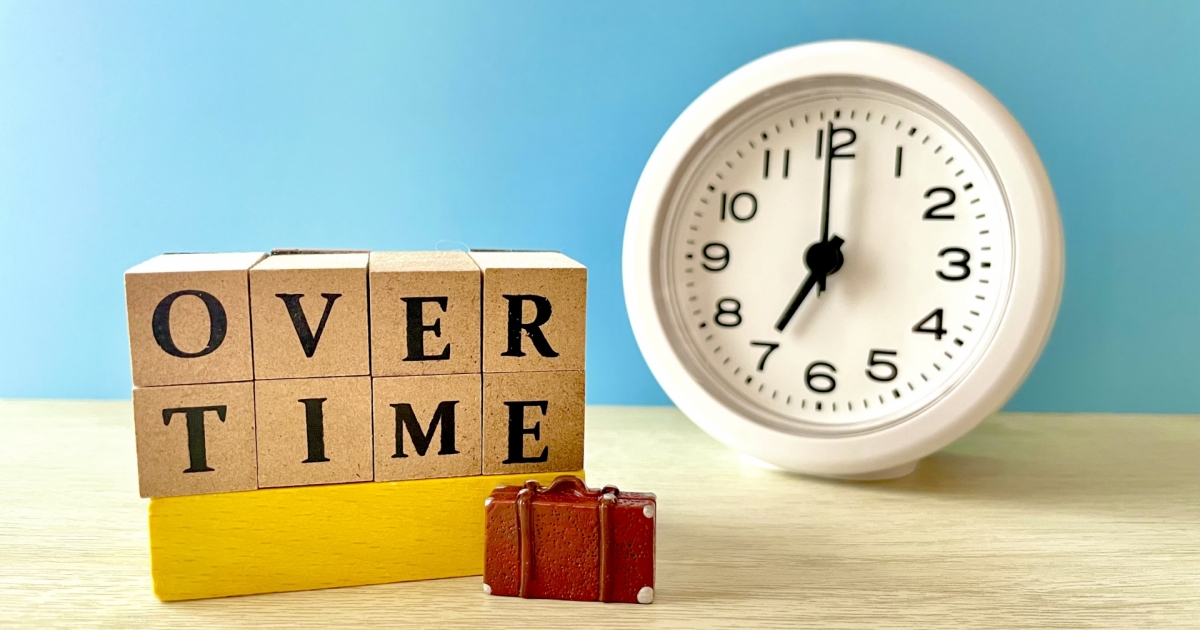 残業（時間外労働）を表現するブロックと時計
